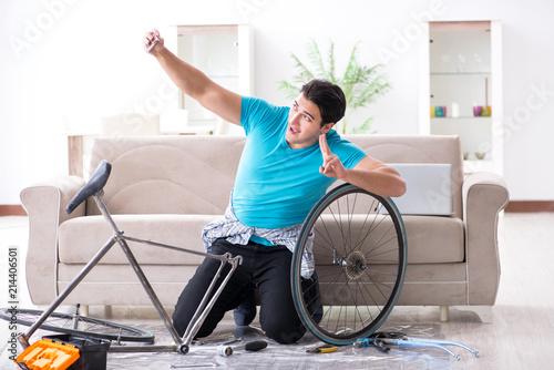 Young man repairing bicycle at home