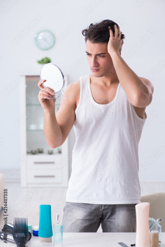 Young handsome man staring in the mirror Young handsome man staring in the mirror
