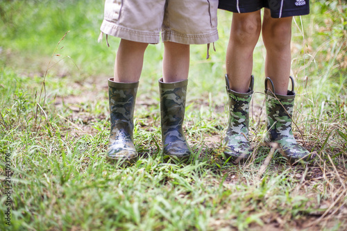 Children wearing camouflaged rain boots bottom half