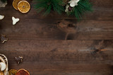 Christmas decoration, gift boxes, dry oranges, cinnamon and Christmas wreath frame background, top view with copy space on brown  wood table surface.