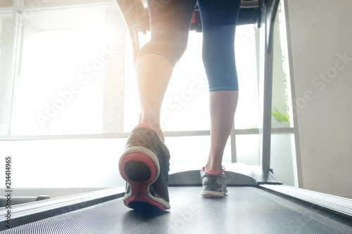 leg of woman running exercise on treadmill in the gym which runner athletic by running shoes. Health and sport concept background,