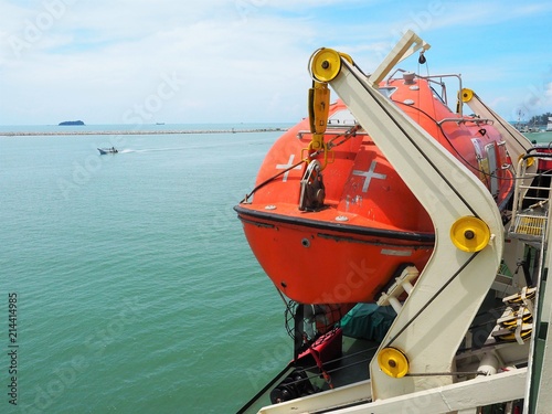 Lift boat is equipped on port side of dive support vessel with blue sea back ground.