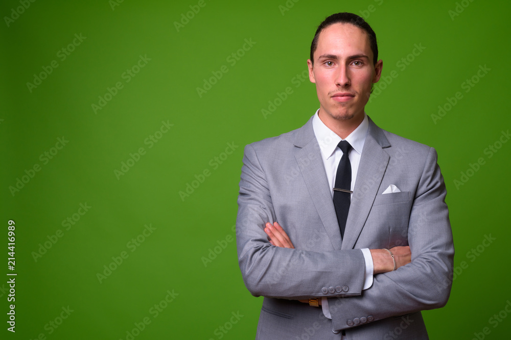 Young handsome businessman against green background Young handsome businessman against green background