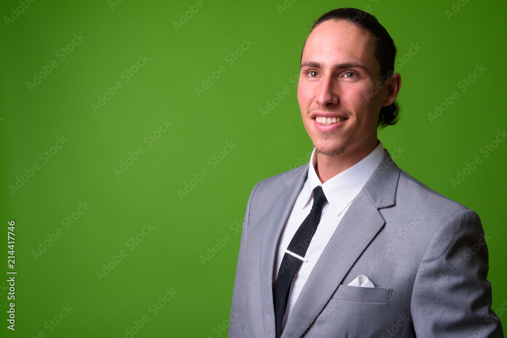 Young handsome businessman against green background Young handsome businessman against green background