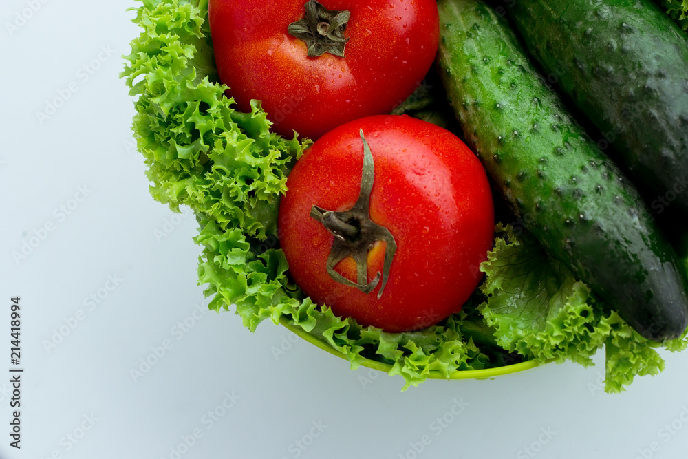 Fresh red tomatoes, green salad and cucumber Fresh red tomatoes, green salad and cucumber