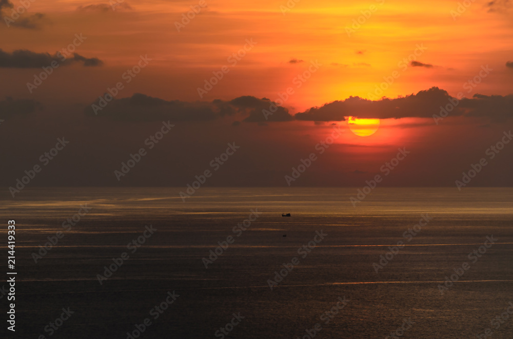 dramatic sunset at sea with cloudy sky.