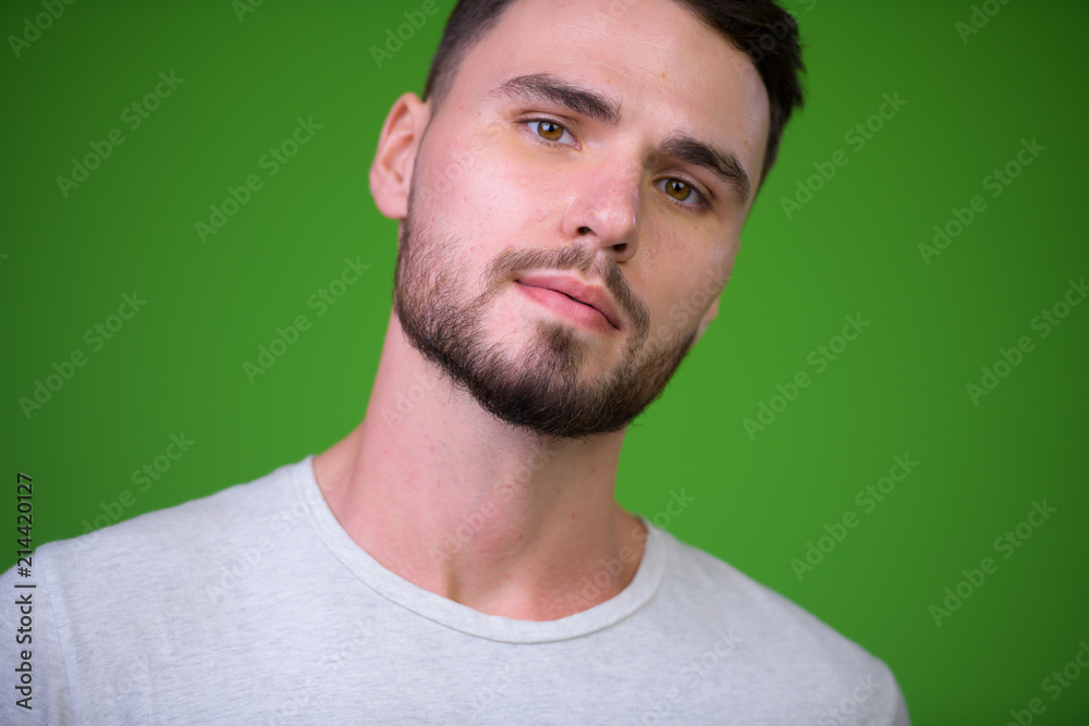 Young handsome bearded man against green background Young handsome bearded man against green background