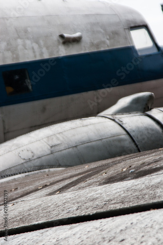 Detail of a vintage abandoned old airplane. Vertical image of wing and cabin. No people.
