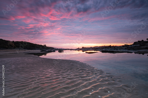 Sunrise reflecting in a pool of water at an Australian beach alongside the iconic Great Ocean Road