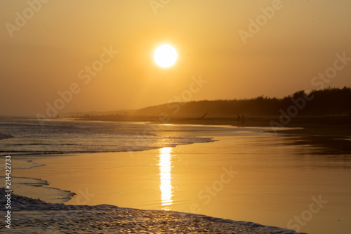 Tropical beach with warm sunset at dusk time photo