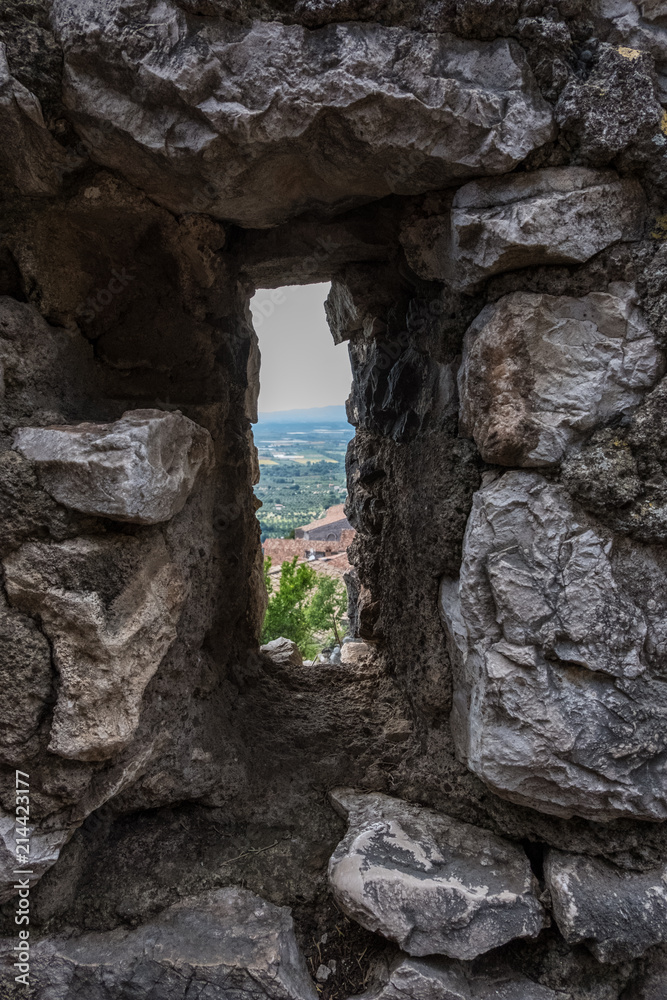 Vertical view of the landscape from an ancient medieval stone wall window. No people.