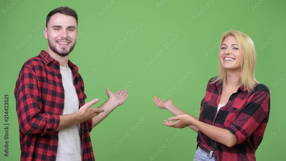Young happy couple showing something together Young happy couple showing something together