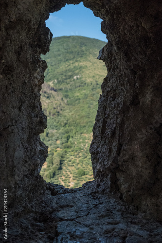 Vertical view of the landscape from an ancient medieval stone wall window. No people.