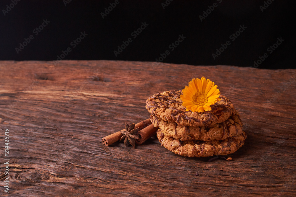 Closeup on stack of chocolate Chip ion wood background with live flowers - cookies for mom on mothers day top view. Selective focus Closeup on stack of chocolate Chip ion wood background with live flowers - cookies for mom on mothers day top view. Selective focus