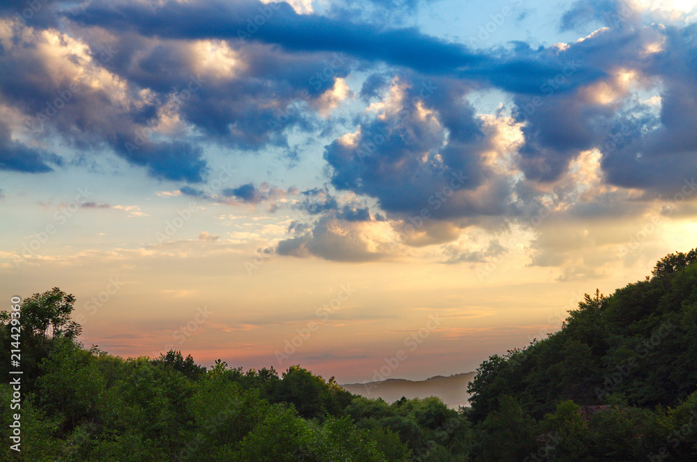dark blue clouds of the evening sky floating above the forest to the horizon line dark blue clouds of the evening sky floating above the forest to the horizon line
