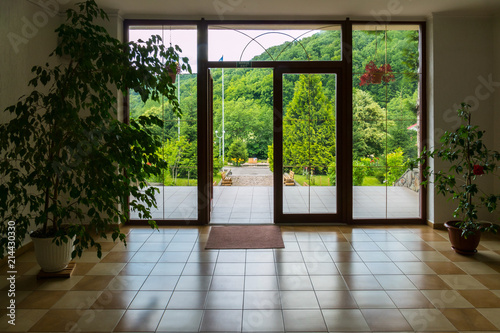 foyer building with green tubs of flowers and a beautiful view of the mountains through glass doors