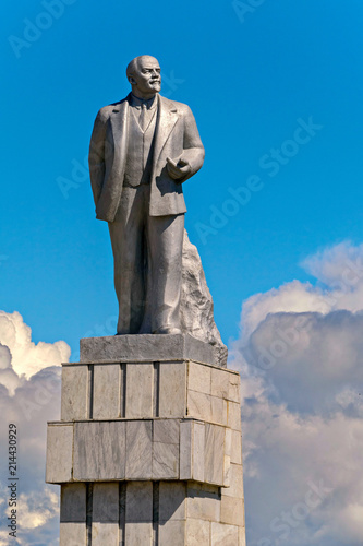 Monument to the totalitarian leader against the blue sky with white clouds