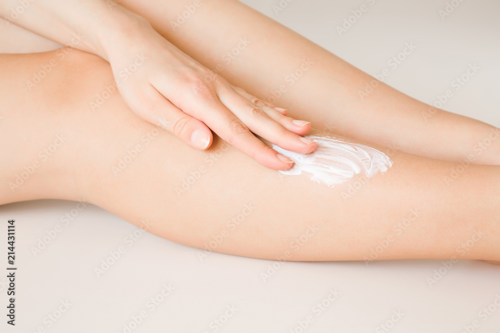 Beautiful, elegant woman's hand applying moisturizing cream on her leg. Care about clean, soft, smooth skin. Healthcare concept. Beautiful, elegant woman's hand applying moisturizing cream on her leg. Care about clean, soft, smooth skin. Healthcare concept.