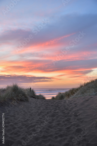 Muriwai Beach im Abendrot hinter den Dünen