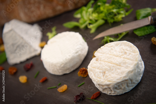 French goats cheeses and bread on background