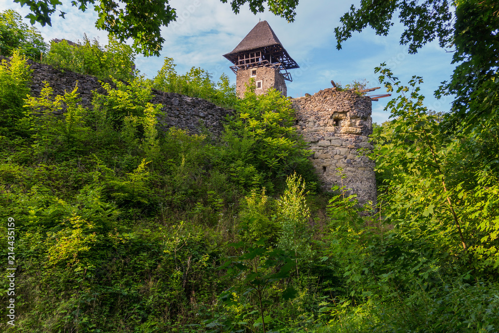 An ancient, partially destroyed fortress lonely stands on top of a green hill An ancient, partially destroyed fortress lonely stands on top of a green hill