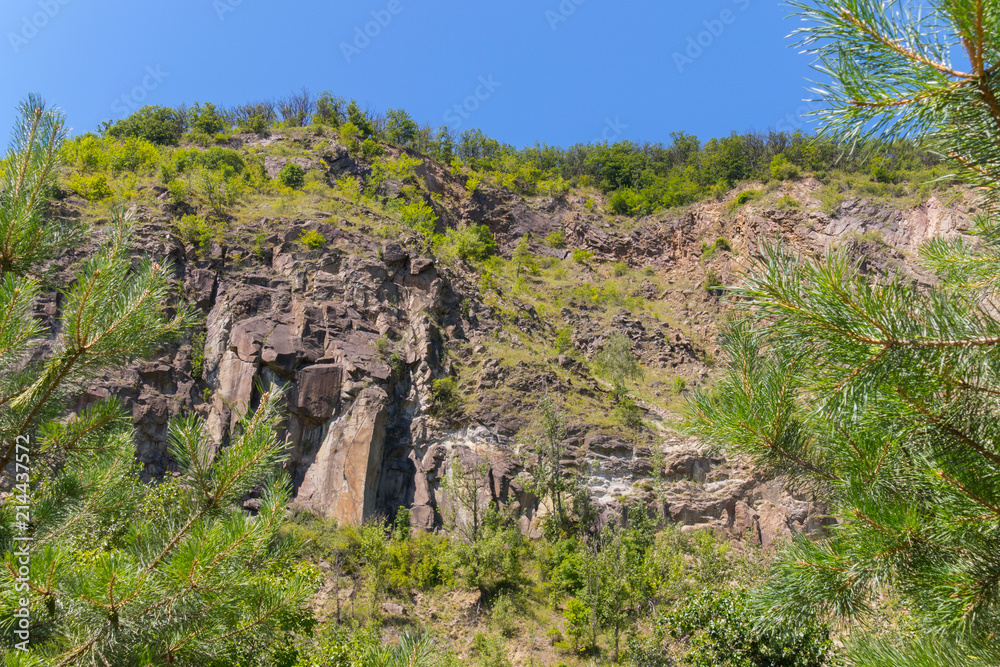 stone hillside with blossoming greenery and trees on top of it stone hillside with blossoming greenery and trees on top of it