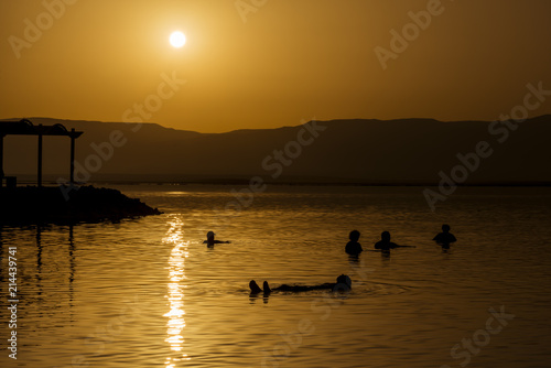 People bathing in the dead sea at sunrise © studiodr