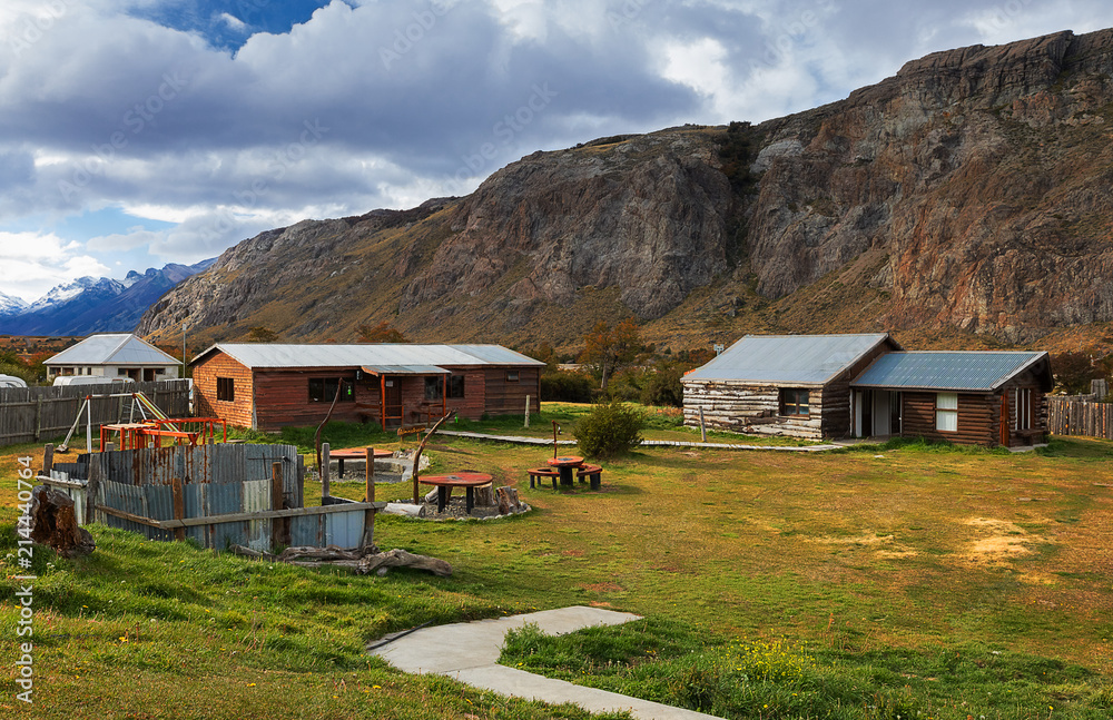 Small wooden houses on the background of mountains. El Chalten. Santa Cruz province. Argentina. Patagonia, South America Small wooden houses on the background of mountains. El Chalten. Santa Cruz province. Argentina. Patagonia, South America