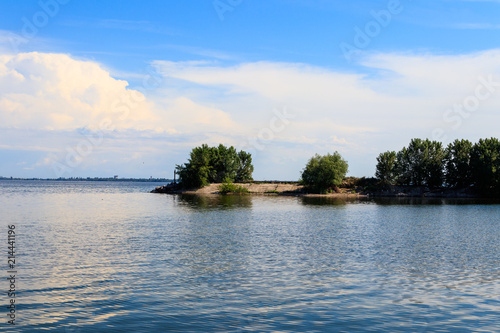 Summer landscape with beautiful lake, green trees and blue sky