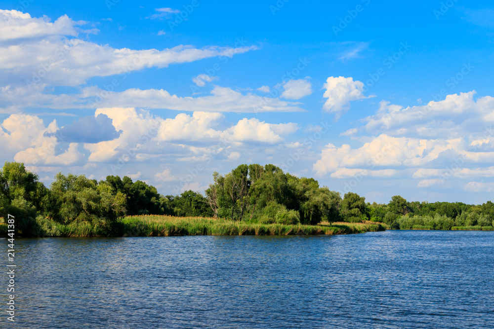 Summer landscape with beautiful lake, green trees and blue sky