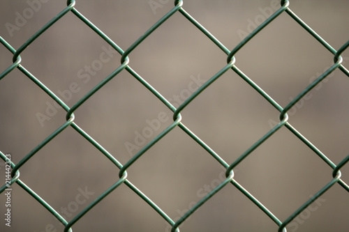 Close-up of isolated painted simple geometric black iron metal wire chain link fence eon dark red background. Fence, protection and enclosure concept.