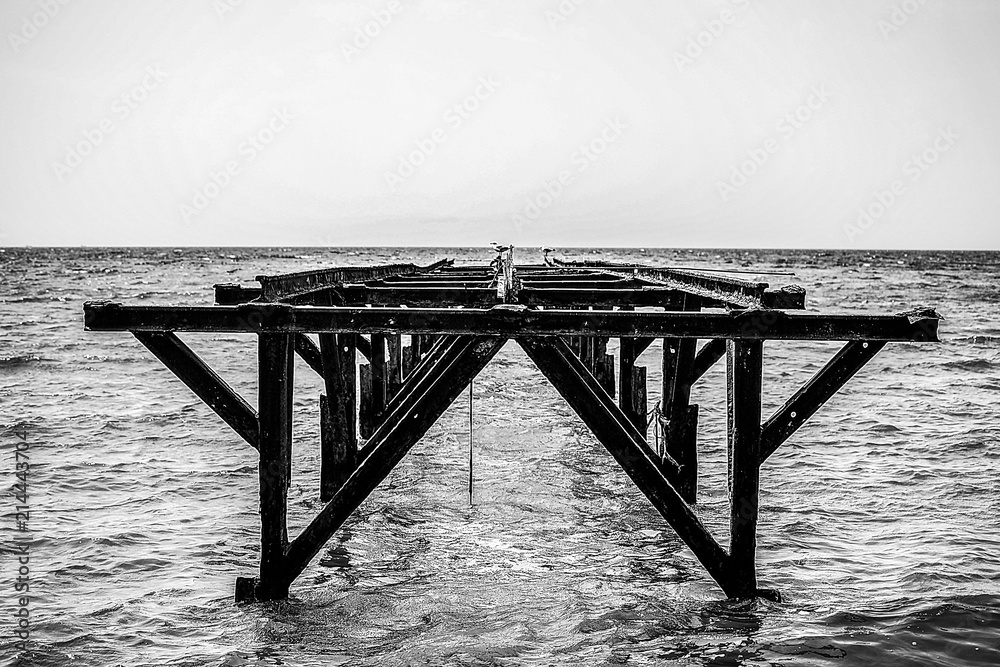 unused iron, rusty bridge in the sea