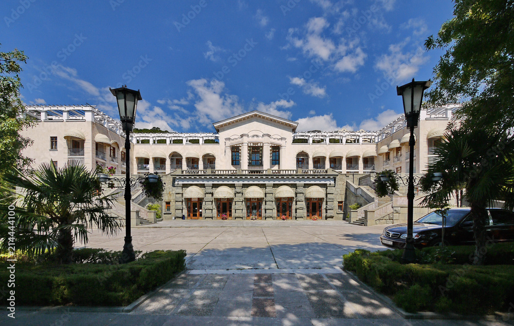 Obraz premium Magnificent view of the palace with beautiful architecture and white walls with stairs from both sides leading to the second floor standing in a park with picturesque nature.