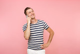 Portrait of fun emotional young man talking on mobile phone, conducting pleasant conversation isolated on trending pastel pink background. People sincere emotions lifestyle concept. Advertising area.