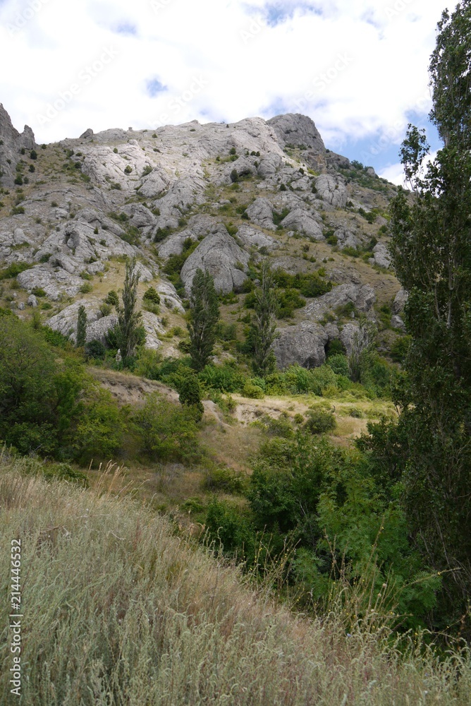 The small mountain slope with its apex, the supporting sky, dotted with huge boulders