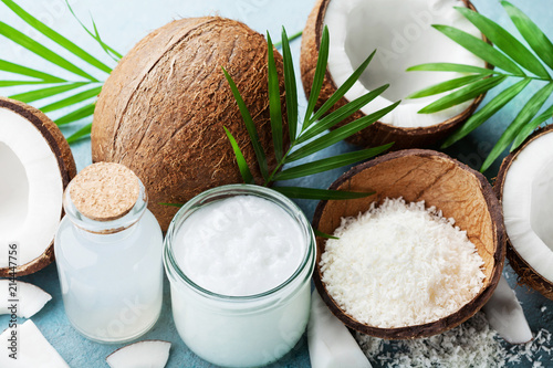 Set of organic coconut products for spa, cosmetic or food ingredients decorated palm leaves. Coconut oil, water and shavings.
