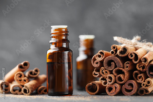 Cinnamon essential oil for spa, aromatherapy, wellness, medical background. photo