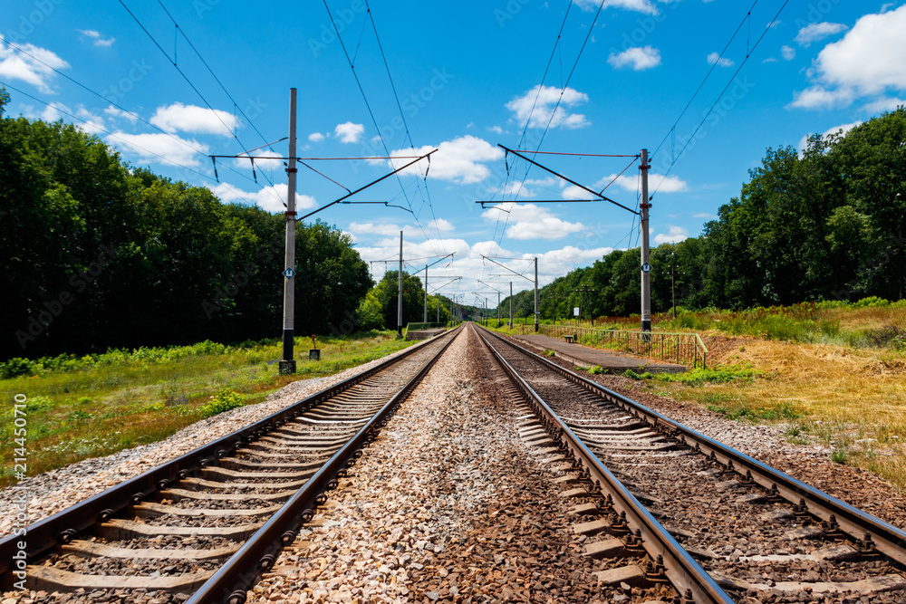 Scenic railroad in rural area and blue sky with white clouds in summer