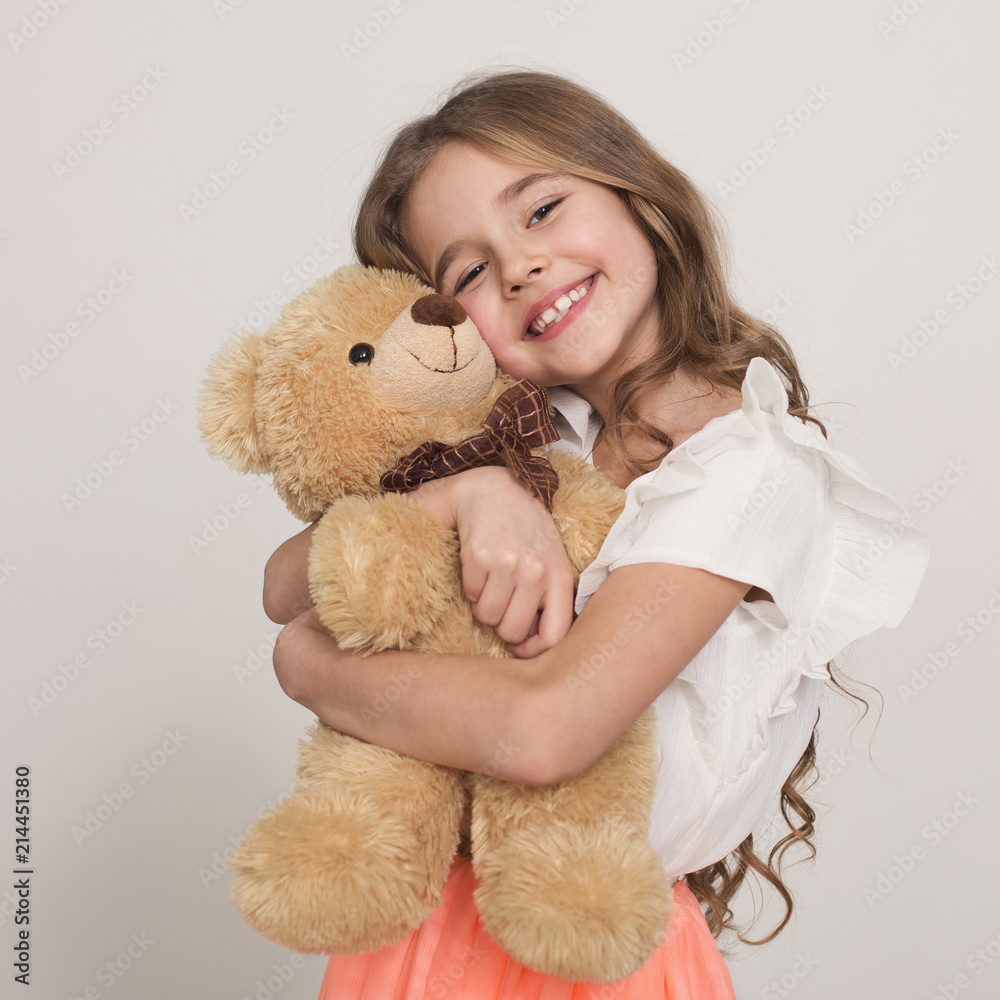 Adorable little girl hugging teddy bear Stock Photo | Adobe Stock