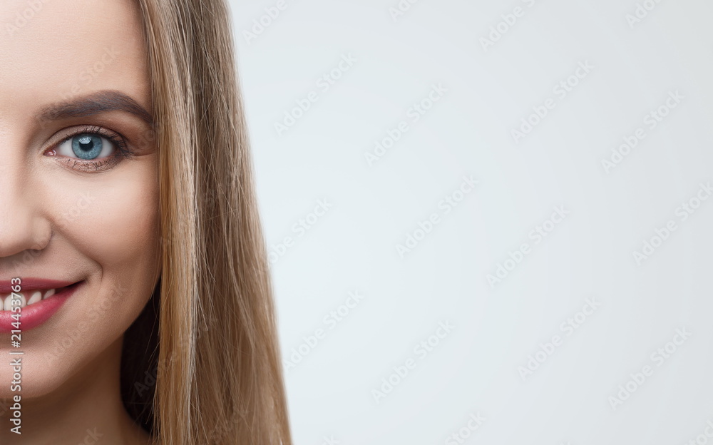 Naklejka premium Half face of smiling beautiful blonde with professional make up