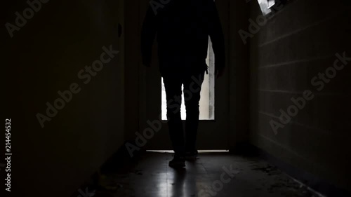 Man walking down a dark brick alley photo