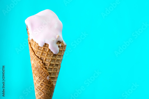 melted ice cream cone on mint blue background