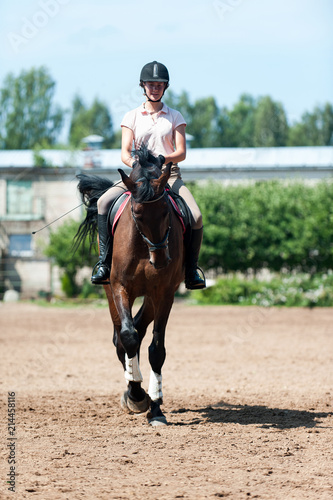 Teenage girl equestrian riding horseback on arena at sport training © AnnaElizabeth