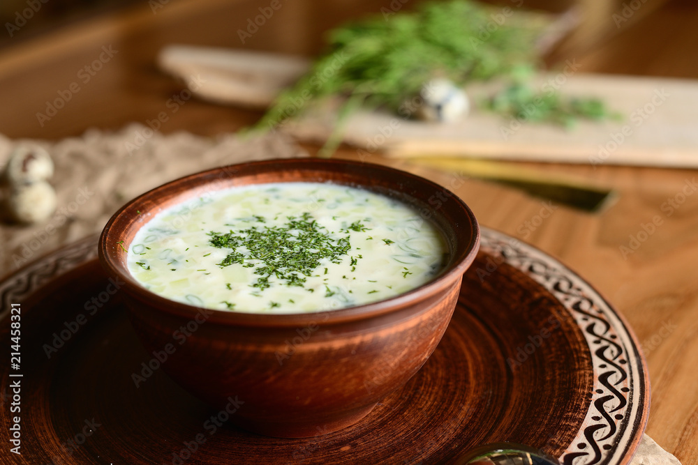 Summer yoghurt cold soup with radish, cucumber, and dill on wooden table. Okroshka. Summer yoghurt cold soup with radish, cucumber, and dill on wooden table. Okroshka.
