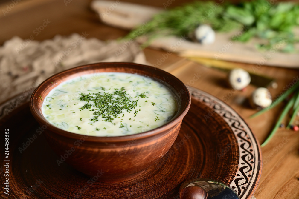 Summer yoghurt cold soup with radish, cucumber, and dill on wooden table. Okroshka. Summer yoghurt cold soup with radish, cucumber, and dill on wooden table. Okroshka.