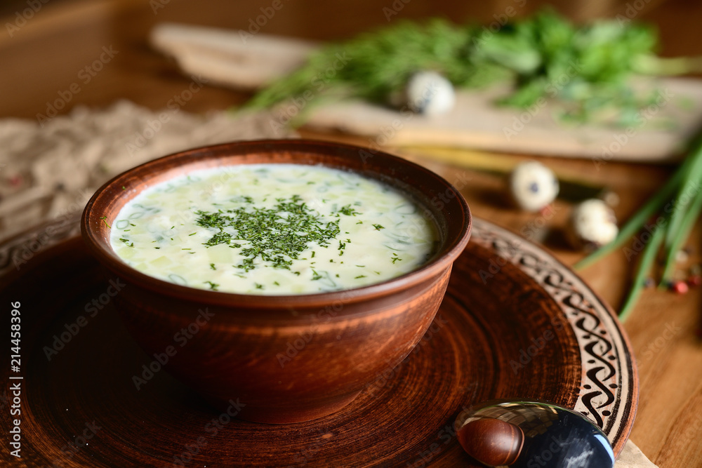 Summer yoghurt cold soup with radish, cucumber, and dill on wooden table. Okroshka. Summer yoghurt cold soup with radish, cucumber, and dill on wooden table. Okroshka.