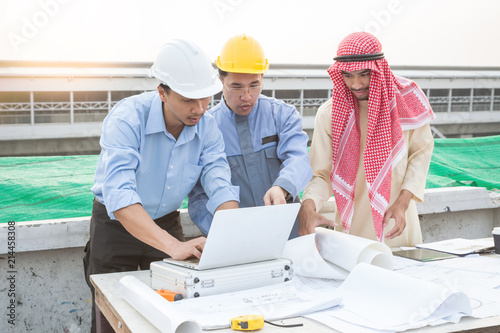 Muslim businessman  engineer  architect and worker team discussing about building plan for construction at job site. Teamwork collaboration relation concept