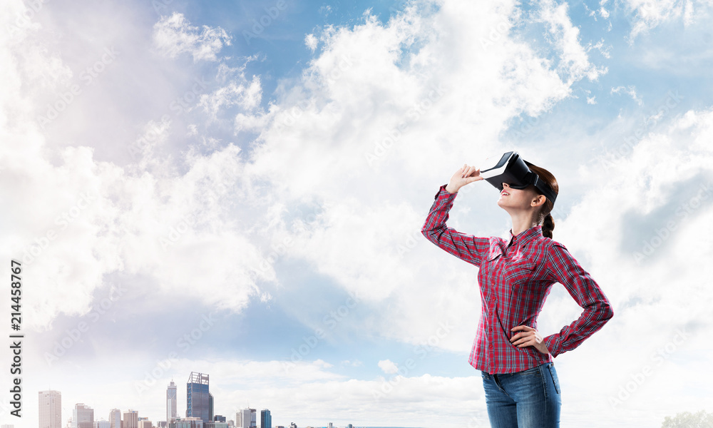 Girl in checked shirt wearing VR glasses experiencing another re Girl in checked shirt wearing VR glasses experiencing another re