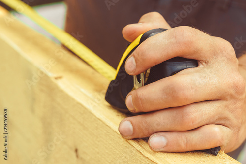 the worker makes measurements with a tape measure