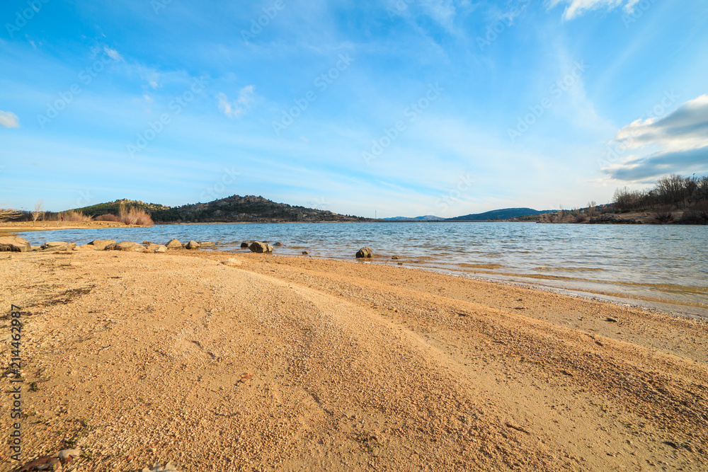 Beautiful lake in the mountains at sunset on a sunny day with blue sky  